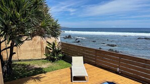 A wooden deck with a pool, a lounge chair, and a view of the ocean. - Waterfront villa with swimming pool. Exceptional view (saline les bains)