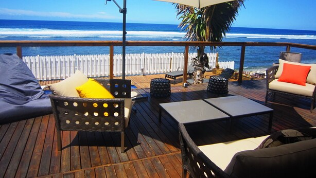 A wooden deck with outdoor furniture, including a sofa and chairs, under a large umbrella. - Waterfront villa with swimming pool. Exceptional view (saline les bains)