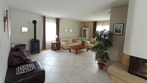 Una sala de estar con un sofá, una mesa de centro, una chimenea y una planta grande en maceta.