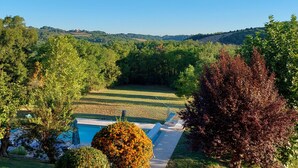 A pool area with a view of a forested landscape.