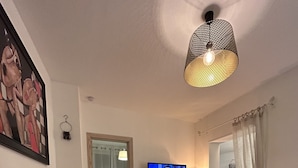 En stue med fjernsyn, stol, lille bord og sofa.