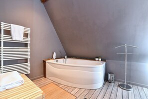A modern bathroom with a freestanding bathtub, wooden flooring, and a towel rack. - Villa Joseph **, Apartment 4 people in Kaysersberg - 2 bedrooms (Kaysersberg-Vignoble)