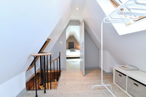 A narrow hallway with a wooden staircase, a white bench, and a ceiling with a skylight. - Villa Joseph **, Apartment 4 people in Kaysersberg - 2 bedrooms (Kaysersberg-Vignoble)