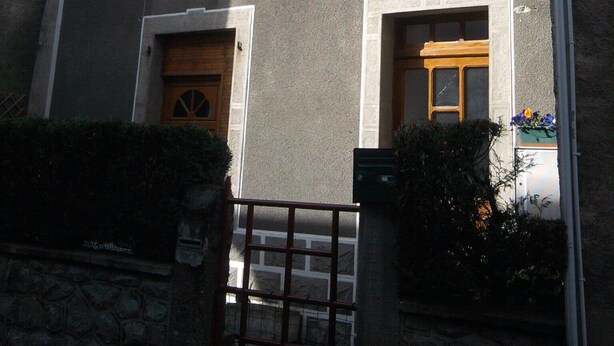 A building with multiple windows, some with shutters, and a number '9' sign above one window. - 4-seater apartment 50 m2 (Laruns)