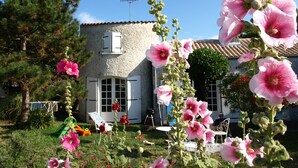 Une maison avec une façade en pierre, une porte blanche et un petit balcon.