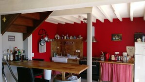 Een keuken met een rode wand, een houten aanrecht en diverse keukenapparaten.