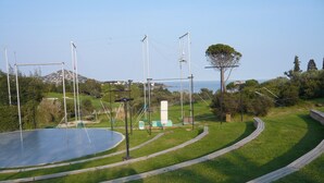 Een park met een groot open veld, een rond circuit en een uitkijktoren.