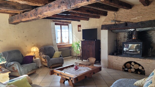 A cozy living room with a fireplace, wooden furniture, and a television.