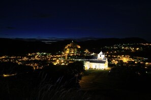 A historic town at night with a prominent church and castle.