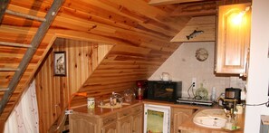A kitchen with wooden cabinets, a microwave, a coffee maker, and a sink. - Charming unclassified studio equivalent to ★ ★. Capacity: 2 people (Murat)