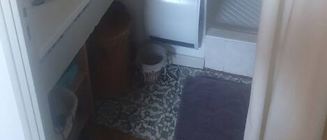 A small, compact bathroom with a white sink, a toilet, and a shower area.