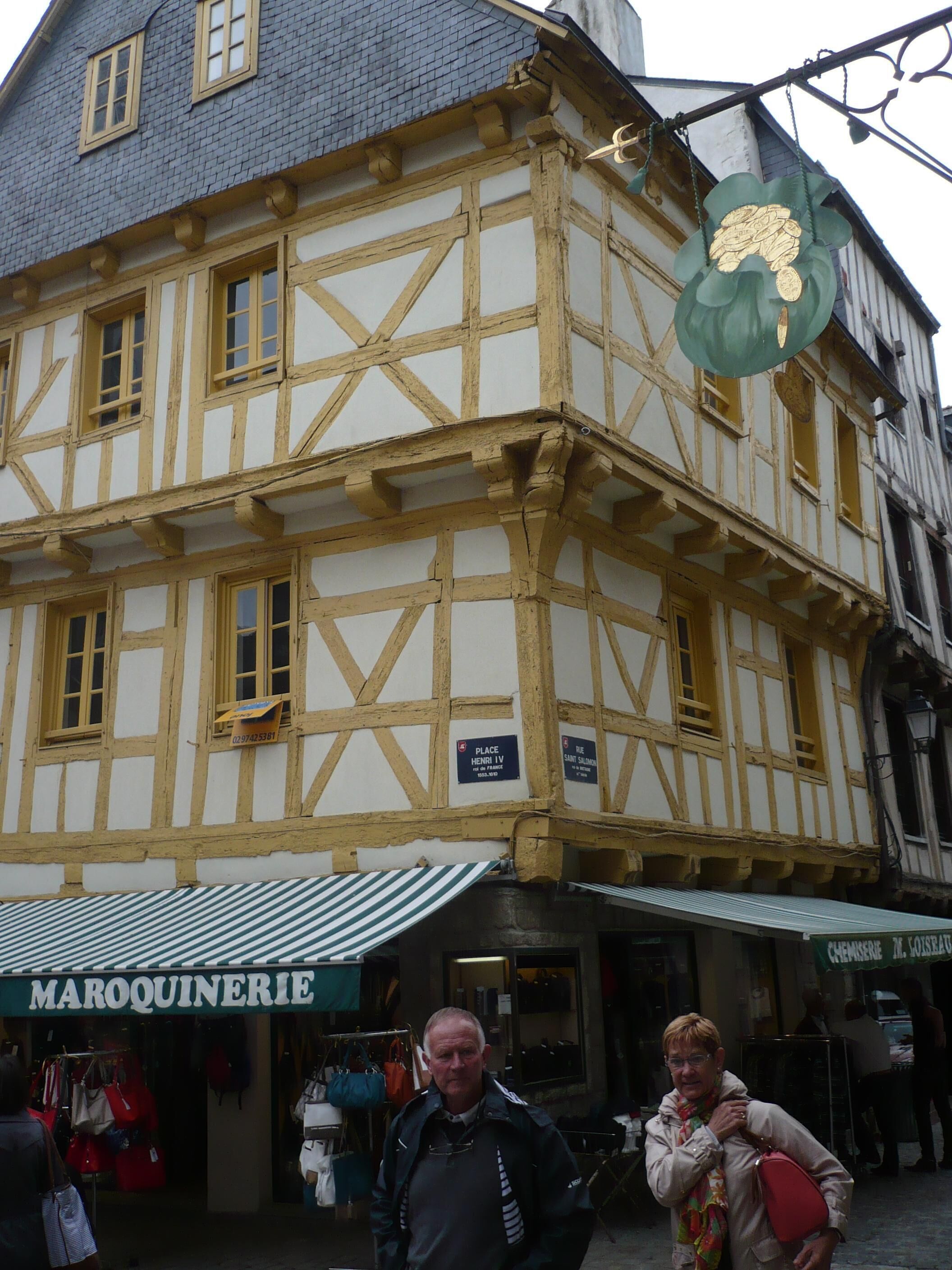 A traditional half-timbered building with a sign for 'Maroquinerie' and 'Chemise M. Loiselle'.