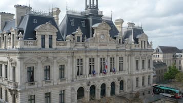 Un bâtiment historique à l’architecture classique, caractérisé par de nombreuses fenêtres, un imposant clocher et des drapeaux.