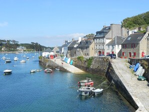 A coastal town with stone buildings, a harbor with boats, and a stone wall along the waterfront. - Holiday home, quiet, near the beach (Le Conquet)
