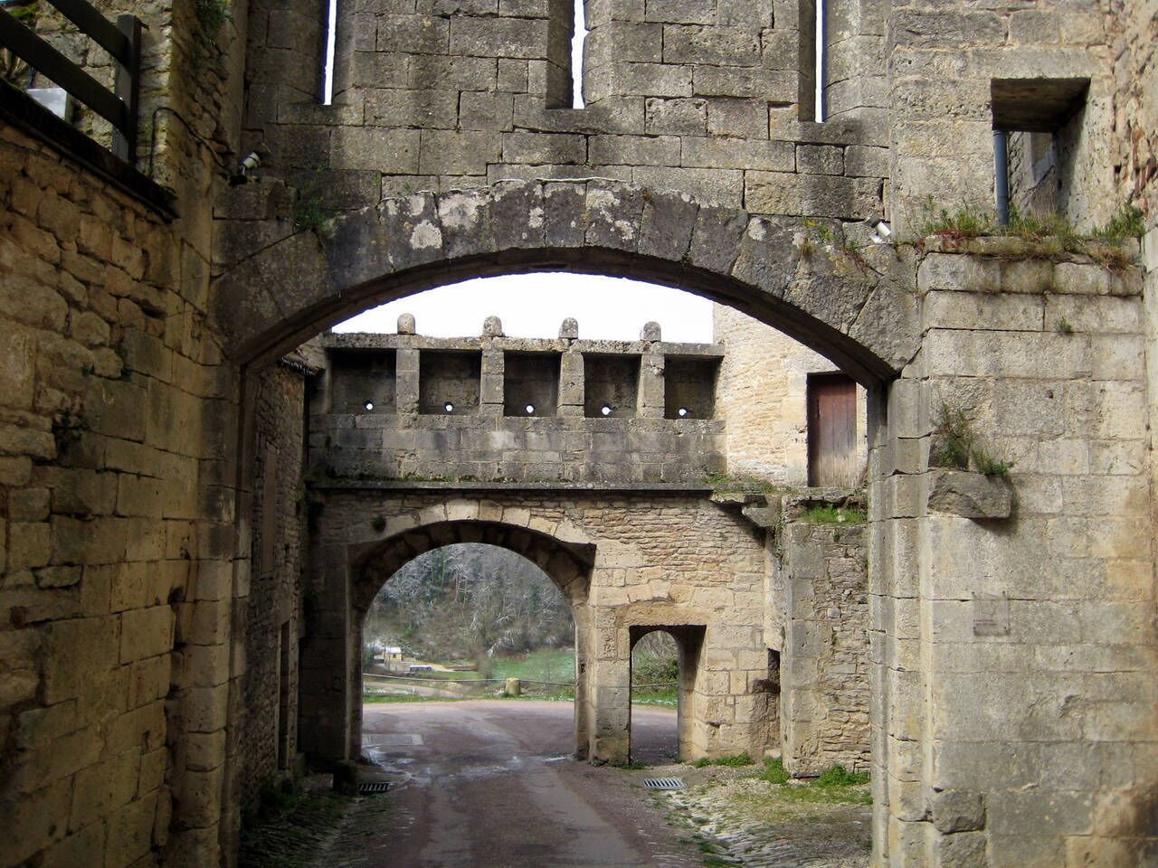 Un antiguo puente de piedra con múltiples arcos que conduce a una carretera.