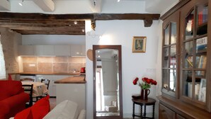 Una cocina moderna con zona de comedor, un espejo y un armario con puertas de cristal.