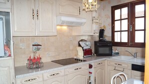 A kitchen with light-colored cabinets, a microwave, a toaster, and a sink.
