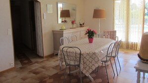 A dining area with a table, chairs, a potted plant, a lamp, and a mirror on the wall. - Air conditioned apartment, fully equipped, nice, for a good holiday. WIRELESS.   (SAINT-AYGULF)