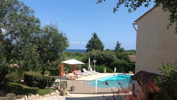 A swimming pool with lounge chairs and umbrellas, surrounded by greenery and a stone pathway. - Air conditioned apartment, fully equipped, nice, for a good holiday. WIRELESS.   (SAINT-AYGULF)