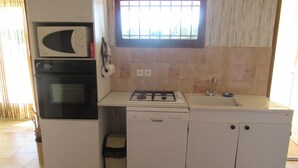 A compact kitchen with a microwave, oven, dishwasher, and sink. - Air conditioned apartment, fully equipped, nice, for a good holiday. WIRELESS.   (SAINT-AYGULF)
