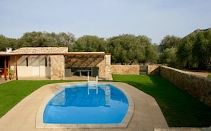 A modern house with a swimming pool, stone exterior, and a covered patio area. - Large villa, panoramic sight on mountain, 3km beach and golf (Occhiatana)