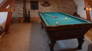 A pool table in a room with a brick wall and wooden beams. - Gîte in the Bay of Somme (Pendé)