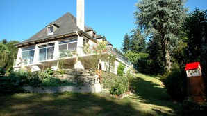 A house with a stone foundation, a chimney, and a balcony with a railing. - The Hydrangeas suite - quality services (in the countryside in Lourdes) (Lourdes)