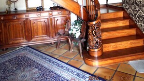 A wooden staircase with a railing, a wooden cabinet, and a patterned rug. - The Hydrangeas suite - quality services (in the countryside in Lourdes) (Lourdes)