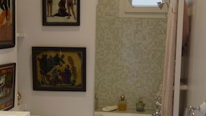 A bathroom with a toilet, a bathtub, and a window. There are two framed pictures on the wall. - quiet and refined apartment (Paris)