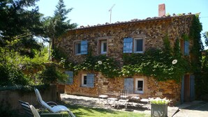 A stone building with a patio area, outdoor seating, and a stone pathway.