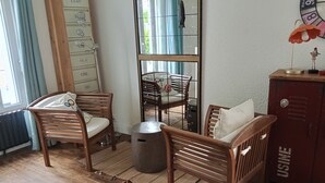 Quarto com mobiliário de madeira, radiador, janela com cortinas e relógio de parede.