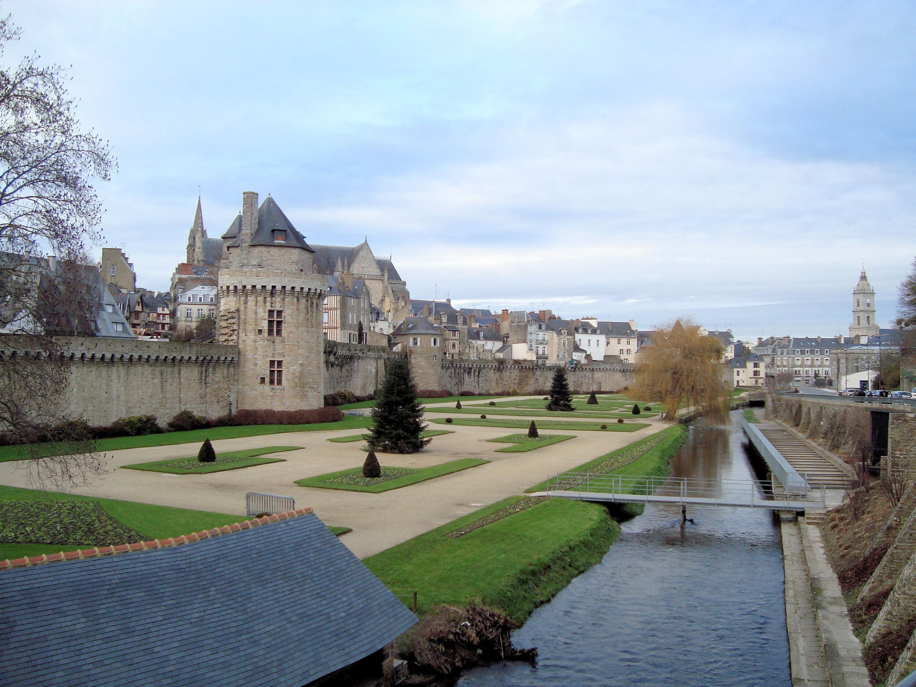 A castle with a moat, a bridge, and a river.