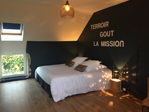 A bedroom with a bed, a window, a wall-mounted light, and a wall with text. - La Maison du Clos du Roi: A Stay in the Heart of the Vineyards & a Wine Tasting Experience (Mercurey)