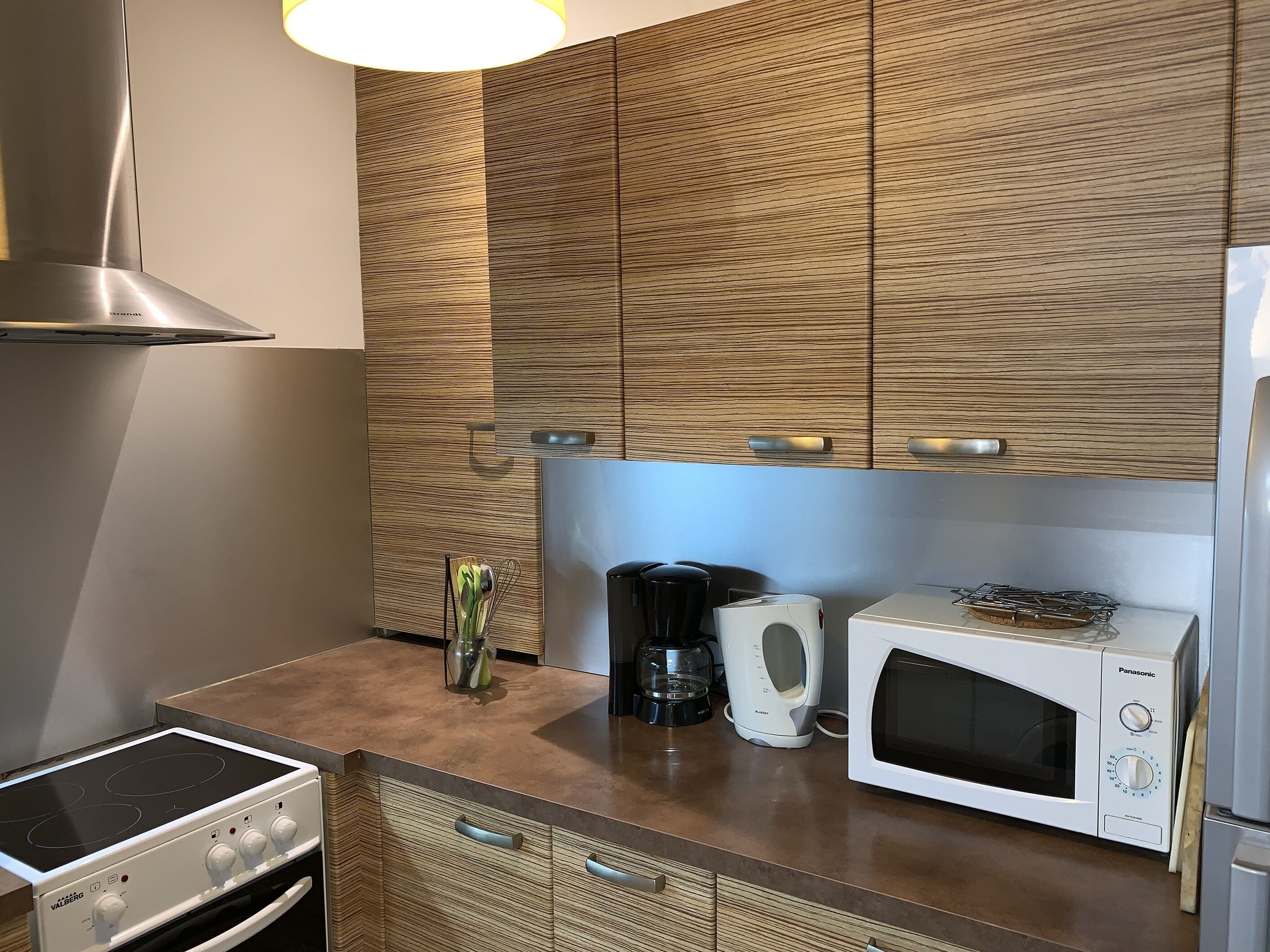 A modern kitchen with a built-in stove, a microwave, and a coffee maker.
