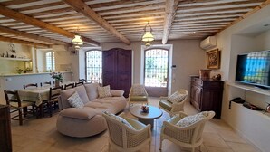 A living room with a sofa, chairs, a coffee table, and a TV. - Fantastic 180° sea view, charm of bygone days, space and confort (Cannes)