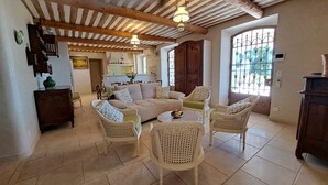 A spacious living room with a sofa, two armchairs, a coffee table, and a dining area with a table and chairs. - Fantastic 180° sea view, charm of bygone days, space and confort (Cannes)