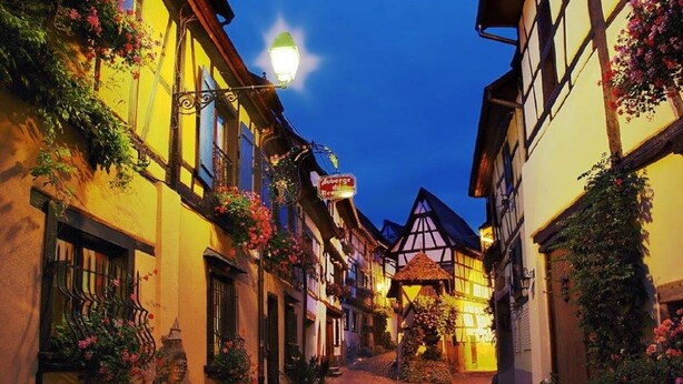 A narrow cobblestone street lined with traditional half-timbered buildings, some with flower boxes and a sign indicating a restaurant. - Terraced country house, 10 minutes from the slopes, at the foot of the mountains  (Breitenbach-Haut-Rhin)