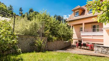 Une maison à deux étages avec un mur en pierre et un balcon.