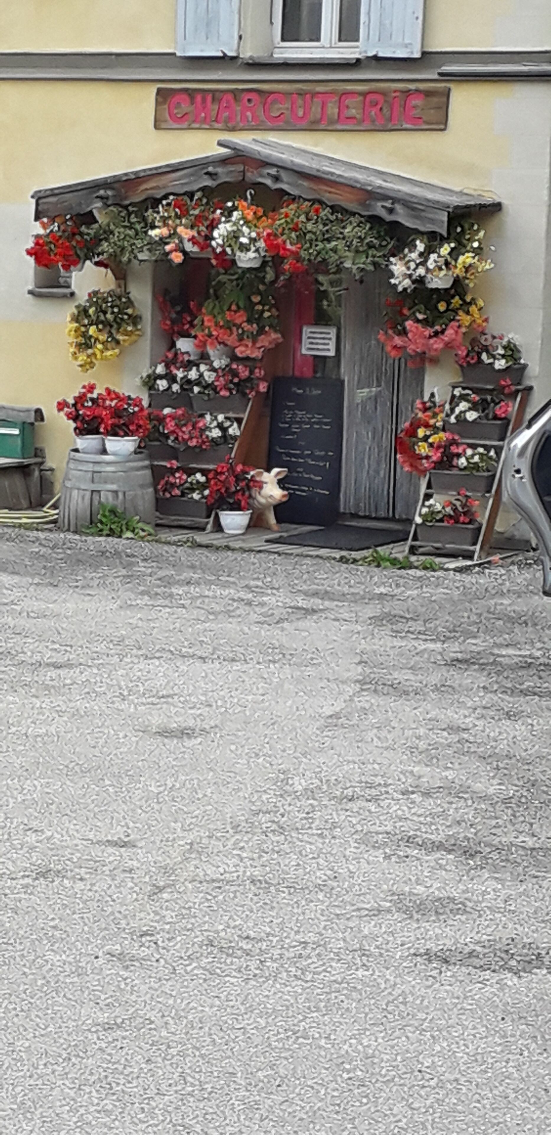 A flower shop with a sign reading "CHARCUTERIE" and various potted plants displayed outside.