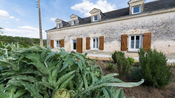 A two-story house with a garden in front.