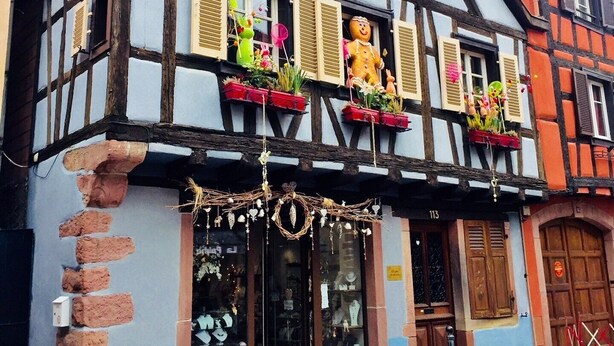 A half-timbered building with a shop entrance, displaying various items. - Manala ***, Alsatian house for 7 to 9 people in Kaysersberg - 3 bedrooms, 2 bathrooms, veranda (Kaysersberg-Vignoble)