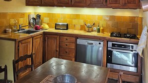 A kitchen with wooden cabinets, a gas stove, a dishwasher, and a toaster.