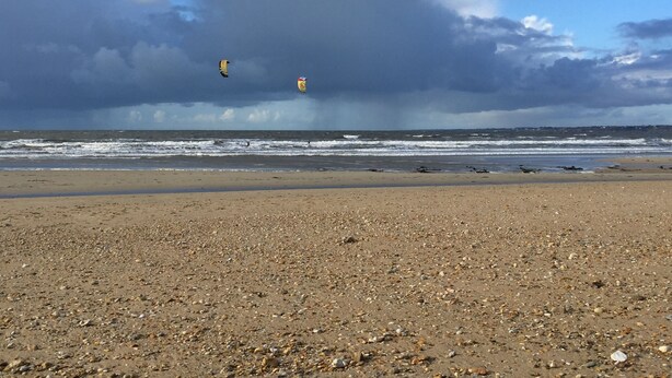 Une plage de galets, avec des vagues.