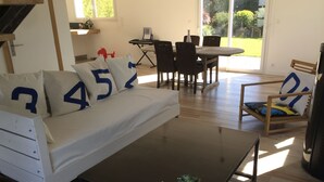 Un salon moderne comprenant un canapé, une table basse et un coin repas avec des chaises et une table.