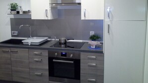 Une cuisine moderne équipée d’appareils électroménagers en acier inoxydable, d’un four encastré et d’un évier.