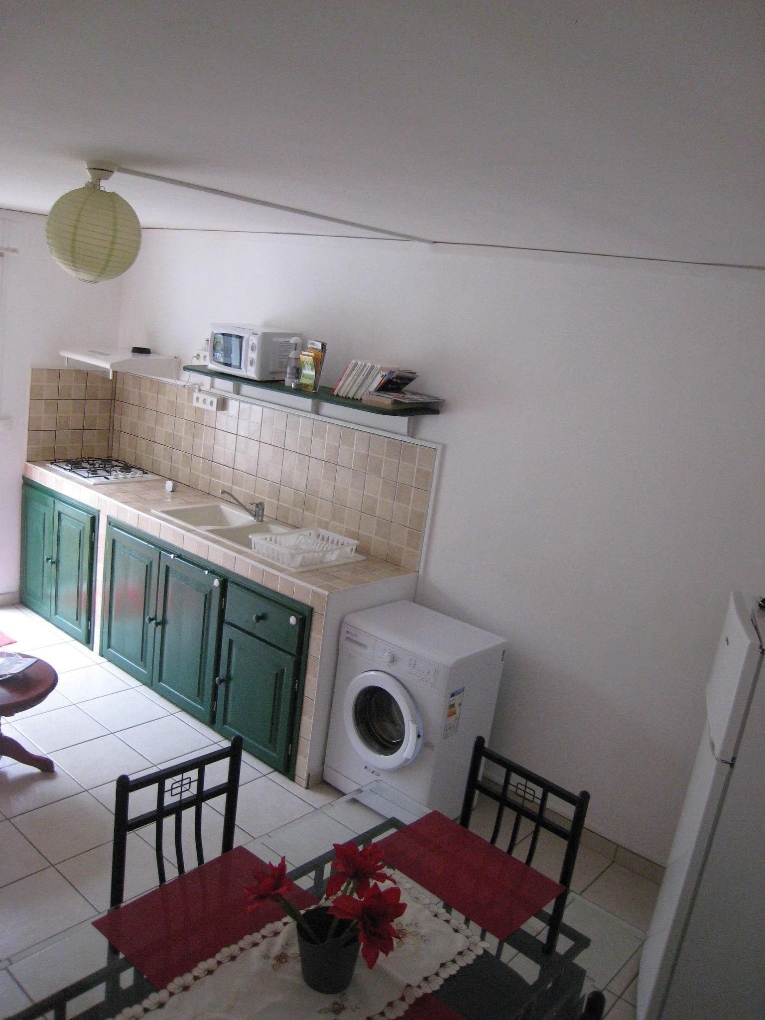 A compact kitchen with a gas stove, microwave, and a built-in washing machine.