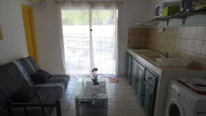 Un salon avec un canapé, une table basse et un lave-linge.