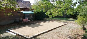 A backyard with a wooden deck, a swing set, and a covered seating area.