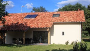 Un edificio con techo de tejas, una ventana pequeña y un letrero en la pared.