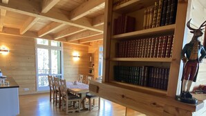A wooden interior with a bookshelf, a fireplace, and a dining area. - Superb chalet apartment with views of the Cerdagne - 3 minutes from the cable cars (Font-Romeu-Odeillo-Via)
